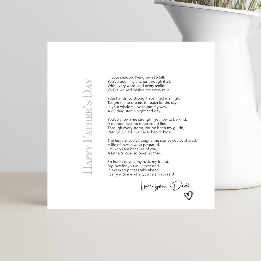 Greeting card with a Father's Day message on a white surface with a vase of dried flowers.