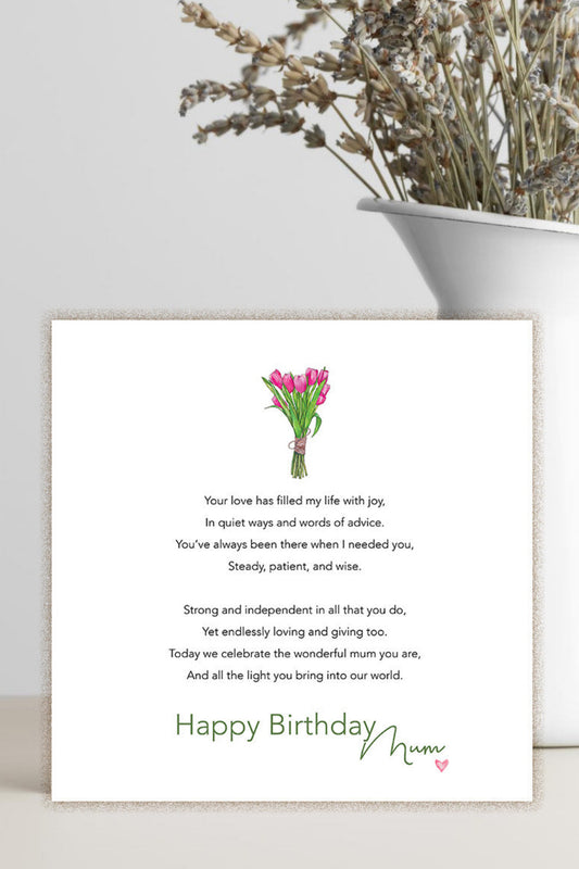 A square white birthday card with a poem, a small pink flower illustration, and the text 'Happy Birthday Mama,' styled on a light surface beside a white vase holding dried flowers.