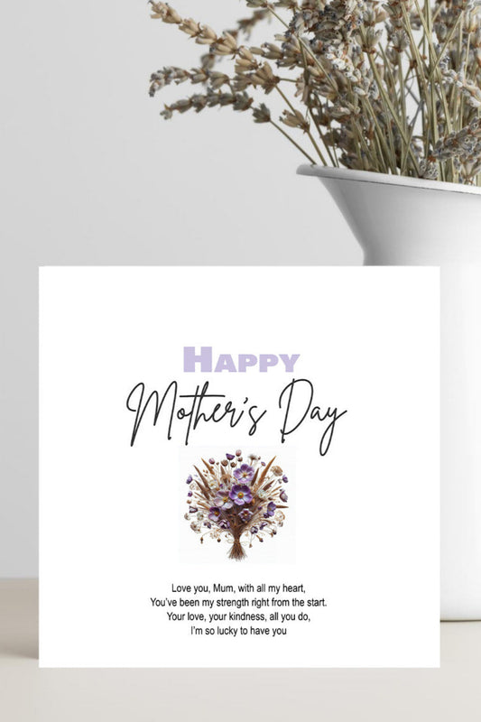 A square Mother's Day greeting card with a white background, featuring the text 'Happy Mother's Day' in lavender and black script, a small purple floral tree illustration, and a short poem below. The card is styled in a home setting on a light surface next to a white vase containing dried flowers.