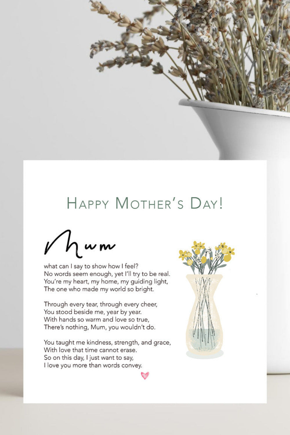 A Mother's Day greeting card with a poem titled 'mum' and a small illustration of yellow flowers in a vase, displayed on a light gray surface next to a white planter with dried flowers.