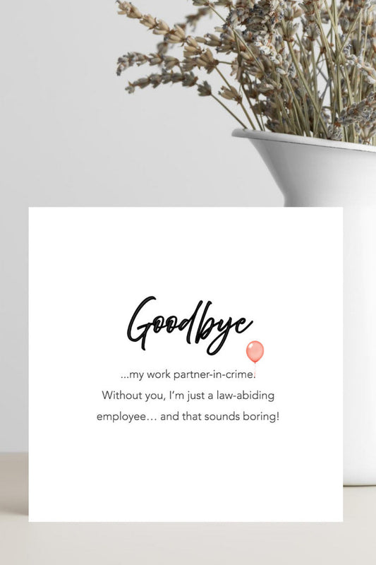 Greeting card with humorous text on a white surface with a vase of dried flowers.