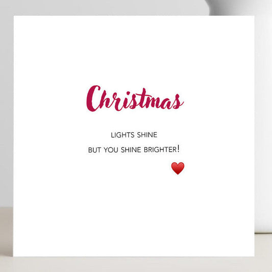 White card with red text and a heart with the wording you shine brighter.