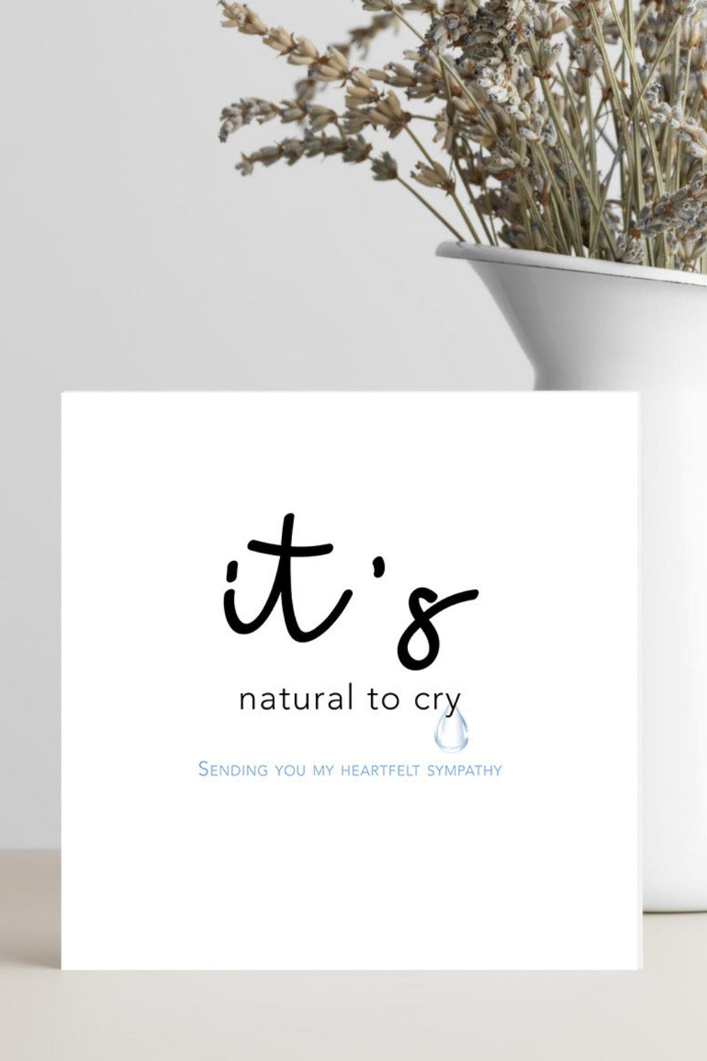 card featuring the words “It’s Natural to Cry” in graceful script, resting on a soft neutral background conveying calm, comfort, and compassion.