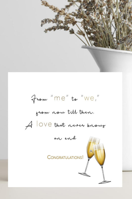 Square wedding card featuring two champagne glasses, one enclosing an engagement ring.  