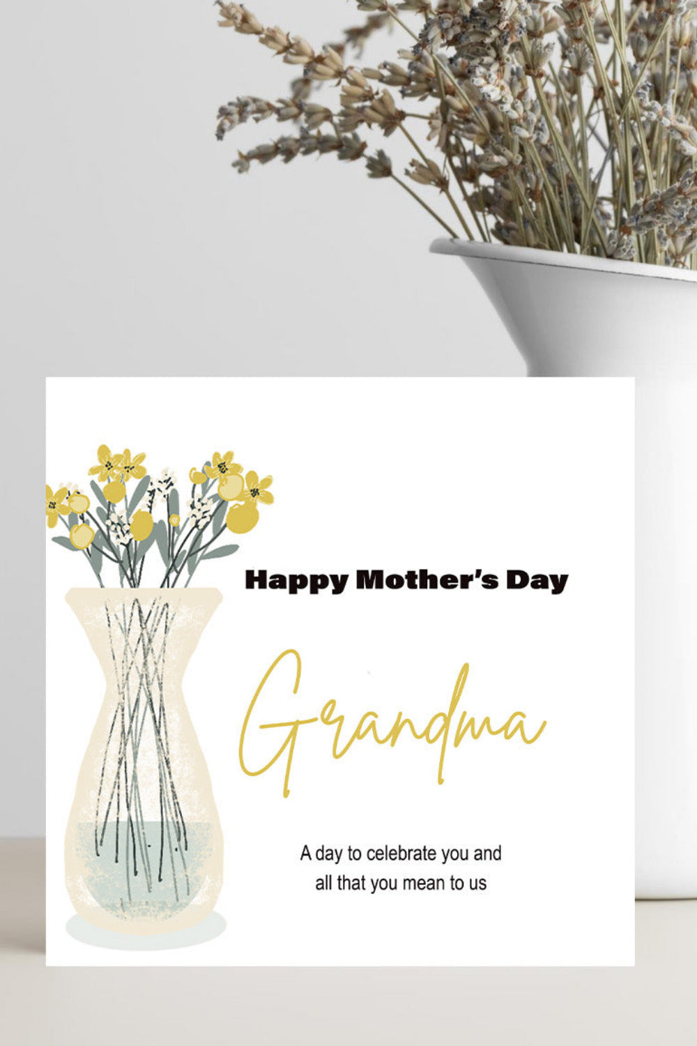 A Mother's Day card addressed to 'Grandma' with an illustration of yellow flowers in a vase, styled on a tabletop next to a white vase with dried flowers.