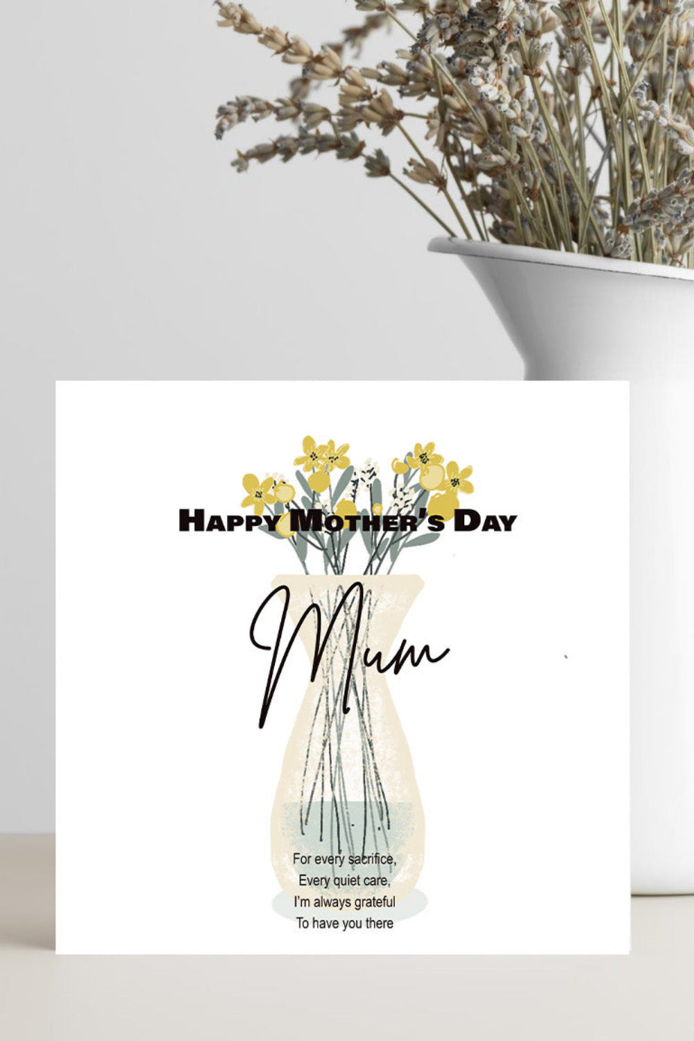 A square Mother's Day greeting card with a floral vase illustration and the text 'Happy Mother's Day Mum' and a short poem, styled on a light surface in front of a white vase with dried flowers.