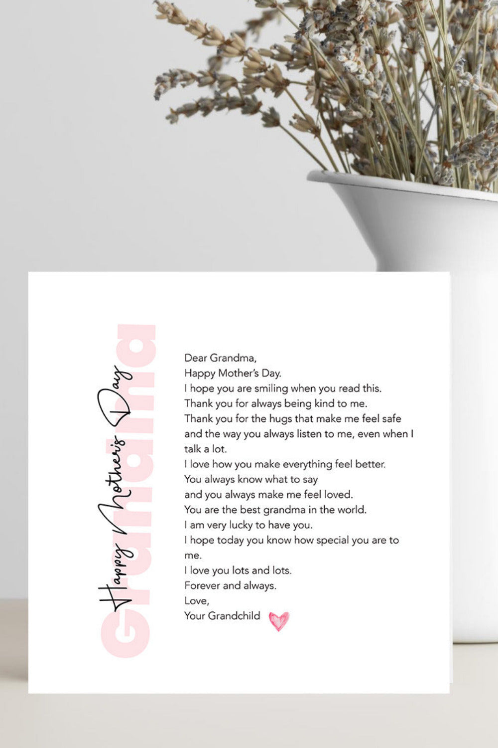 Greeting card with a heartfelt message on a white surface with a vase of dried flowers.