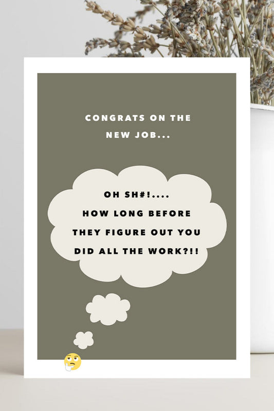 A rectangular congratulations card with a white border and a muted olive-gray background, placed on a light surface beside a white vase with dried flowers. The card reads: 'CONGRATS ON THE NEW JOB.