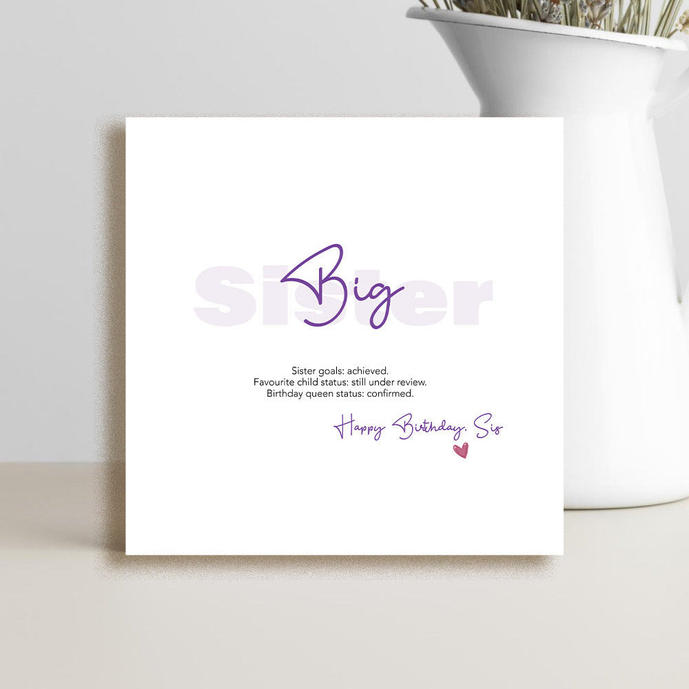 Big sister greeting card with "Sister goals: achieved. Favourite child status: still under review. Birthday queen status: confirmed" printed in bold, modern typography on white card stock.