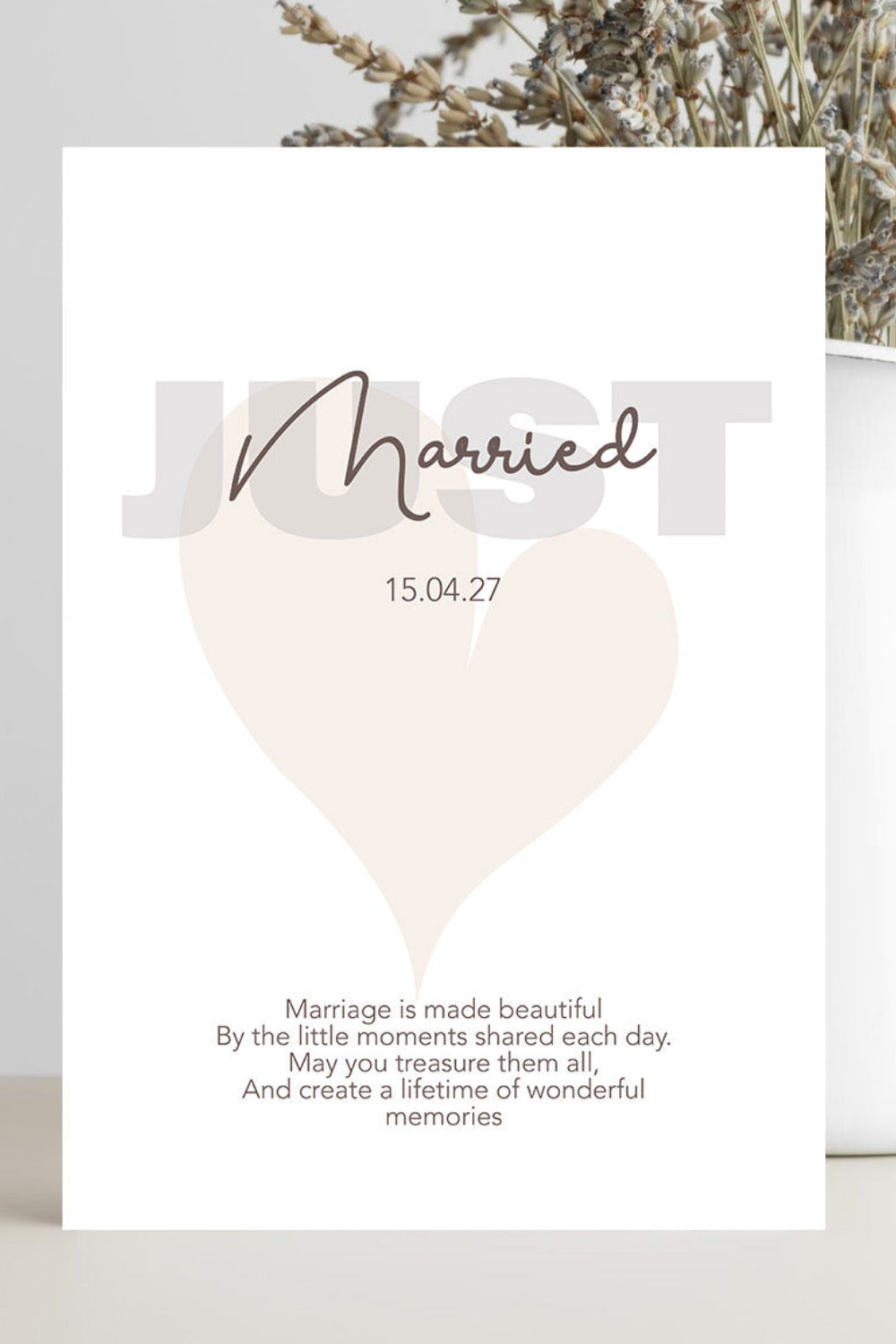 A white wedding invitation card featuring a minimalist design with a large heart, the word 'Married' in script, and a date. 