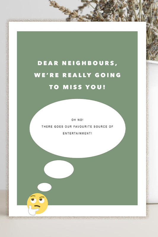 A rectangular greeting card with a sage green background and white border, printed with the text 'DEAR NEIGHBORS, WE'RE REALLY GOING TO MISS YOU!' and a thought bubble graphic. The card is photographed standing on a light surface beside a white vase with dried stems.
