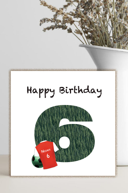 A square greeting card with a white background, featuring the text 'Happy Birthday' above a large dark green textured number 6, styled next to a white vase with dried flowers.