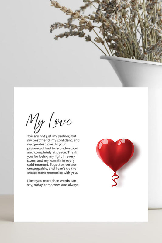 A square white card with the handwritten title 'My Love' and a short sentimental poem, alongside a red heart-shaped balloon illustration, displayed on a light surface next to a white vase with dried flowers.