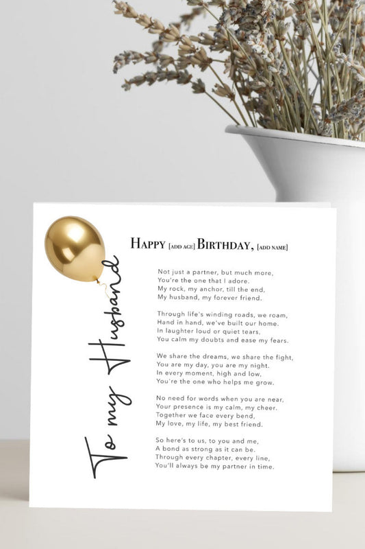 A square birthday card for a husband, featuring a poem and a gold foil balloon graphic, styled in a white vase with dried flowers on a light gray surface.