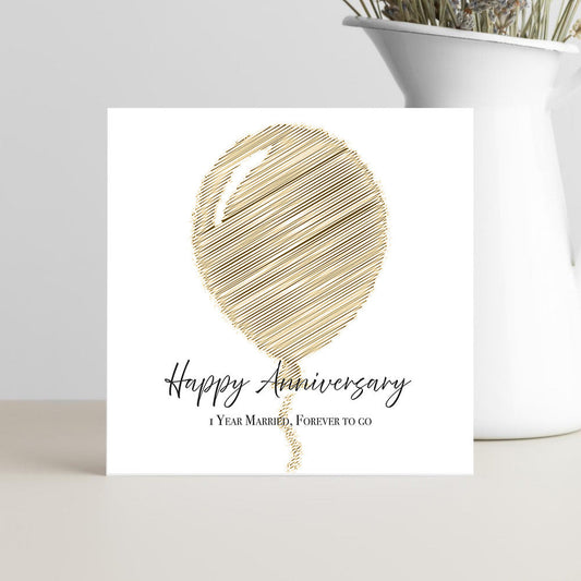Greeting card with gold balloon design and 'Happy Anniversary' text on a white background.