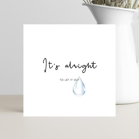 A simple, elegant condolence greeting card featuring the words “It’s Alright to Let It Out” in graceful script, resting on a soft neutral background with a calm and comforting mood.