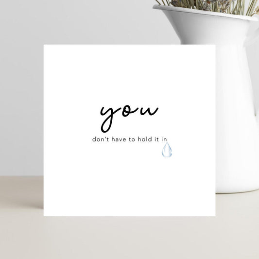 A soft, minimalist condolence greeting card featuring the words “You Don’t Have to Hold It In” in elegant lettering, set against a calm neutral background conveying comfort and compassion.