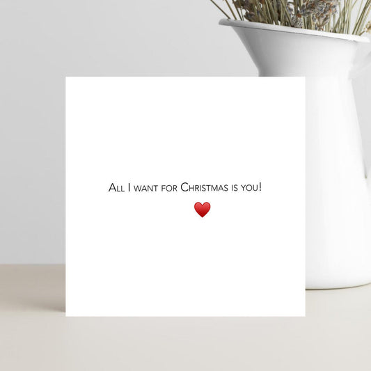 Minimalist Christmas card with the caption All I Want for Christmas and a red heart.