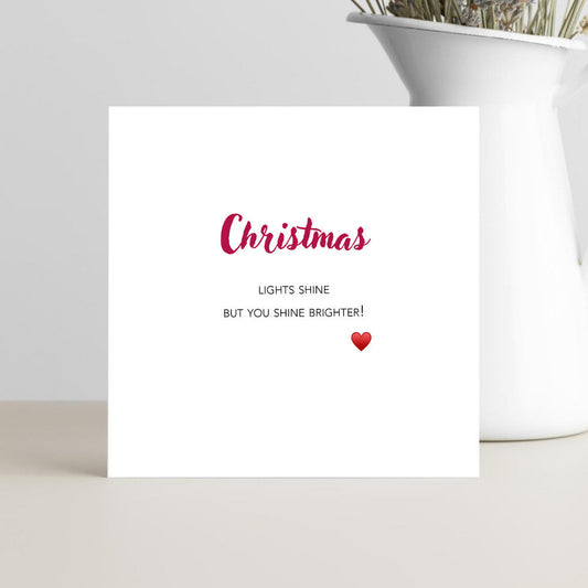 White card with red text and a heart with the wording you shine brighter.